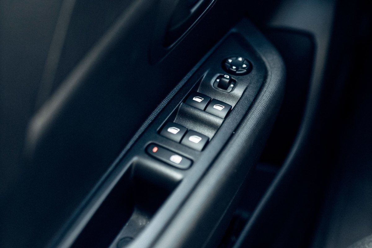 Car door armrest switch panel with four window switches and a lock switch
