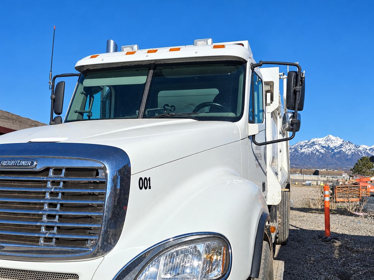 White Freightliner work truck from the front corner with a clean two-piece windshield