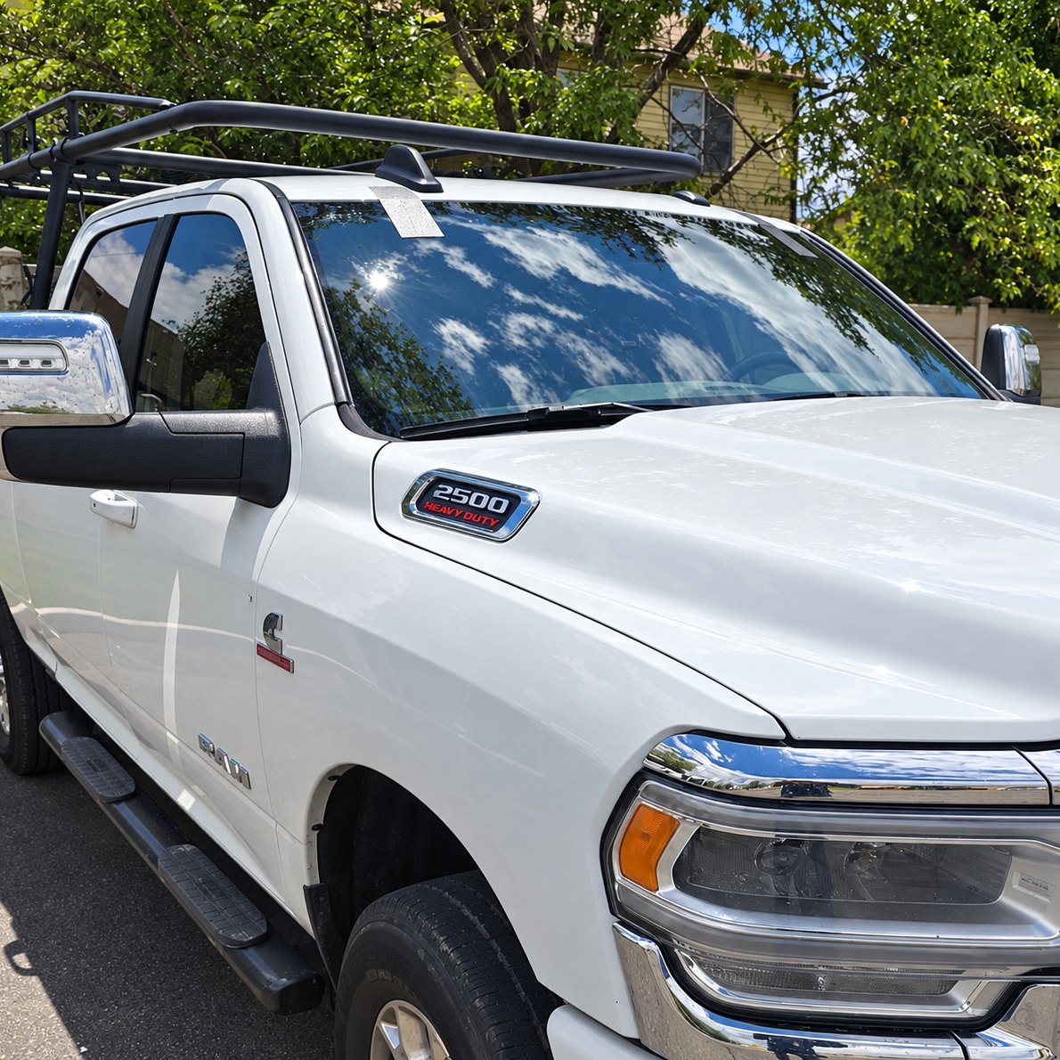 White Ram 2500 Heavy Duty pickup with a newly fitted windshield reflecting the sun